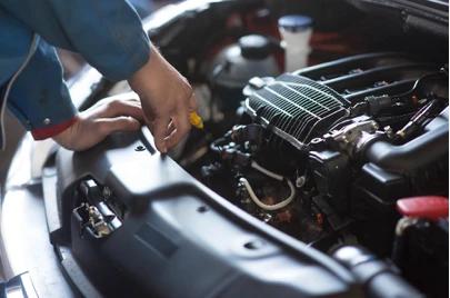 Auto technician observing vehicle engine
